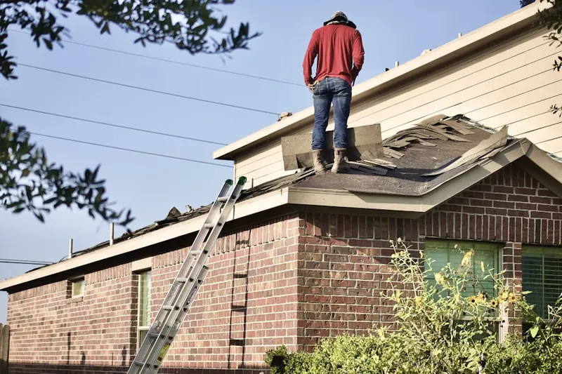 Professional roofer working on a residential roof in Deep Ellum